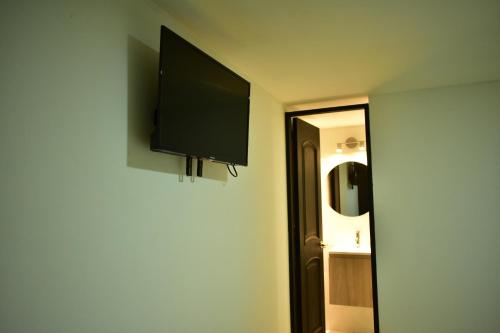 een flatscreen-tv aan de muur van een kamer bij Vive como un local en Popayan in Popayan