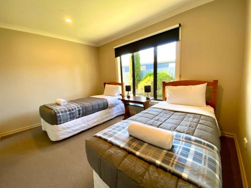 a room with two beds and a large window at Rhoboro Retreat in Twizel