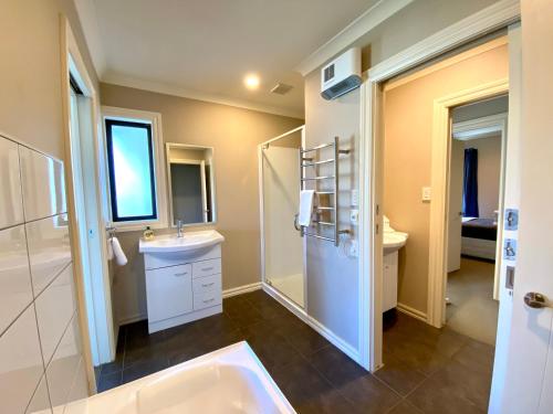 a bathroom with a tub and a sink and a shower at Rhoboro Retreat in Twizel