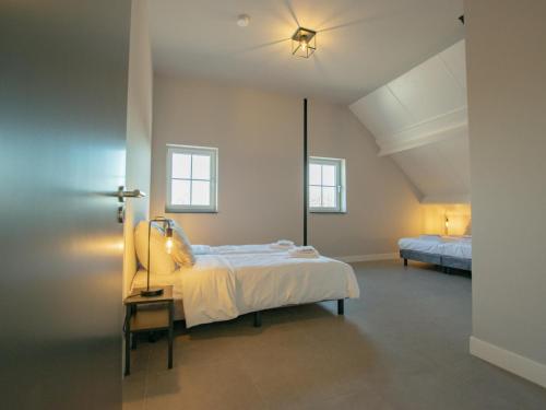 1 dormitorio con 1 cama grande y 2 ventanas en Jonkershof, en Lage Zwaluwe