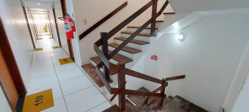 una escalera en una casa con barandilla de madera en COPFL0100 - Condomínio Recanto do Flamengo en Salvador