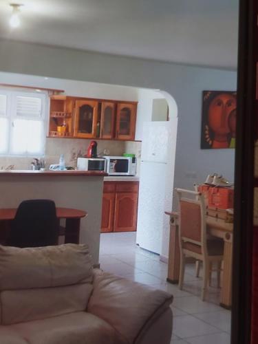 een woonkamer en een keuken met een bank en een tafel bij Tarare in Vieux-Habitants
