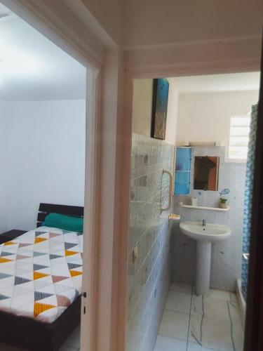 een badkamer met een bed en een wastafel bij Tarare in Vieux-Habitants