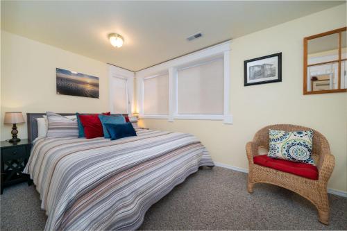 a bedroom with a bed and a chair and a window at Nyevana Beach House in Newport