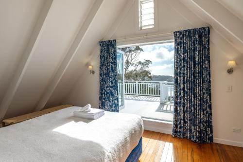 a bedroom with a bed and a large window at Min Y Mor in Onetangi