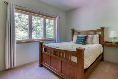 a bedroom with a wooden bed and a window at Haven Hill in Cloverdale