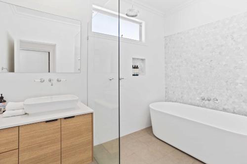 a white bathroom with a tub and a sink at Perfect Palm Beach Townhouse - Hosted by Burleigh Letting in Gold Coast