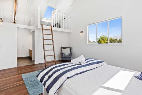 a white bedroom with a bed and a ladder at Perfect Palm Beach Townhouse - Hosted by Burleigh Letting in Gold Coast