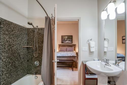 a bathroom with a sink and a shower with a bed at Sea Depoe Bay in Depoe Bay