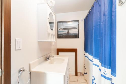 a bathroom with a white sink and a mirror at Rockaway Beachhouse in Rockaway Beach