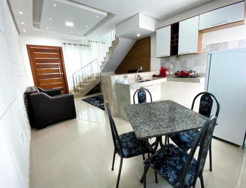 a kitchen with a table and chairs in a room at Apartamentos Villa dos Diamantes in Porto Seguro