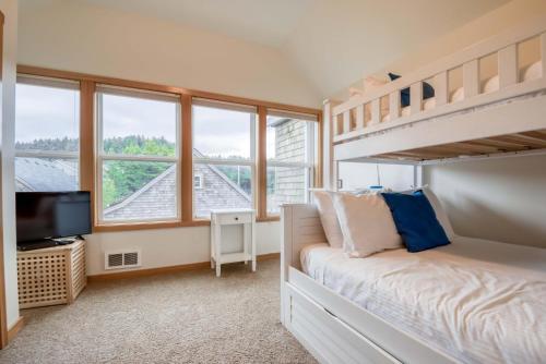 a bedroom with a bunk bed and a tv at Beach Break in Pacific City
