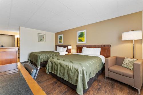 a hotel room with two beds and a chair at Quality Inn & Suites Okanogan - Omak in Okanogan