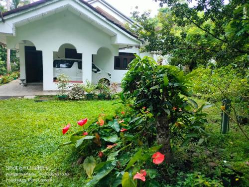 una casa blanca con rosas rojas en el patio en Villa for Surf Weligama with Shisha, en Weligama