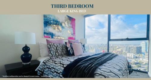 a bedroom with a bed with a view of a city at Platinum Luxury Stays The Grande Large 4 BRM 3 Bath Apt in Melbourne