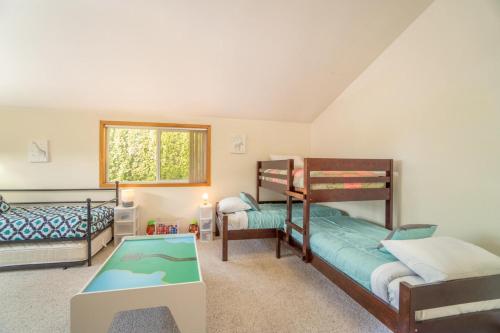 a bedroom with two bunk beds and a table at Moss Quadrant in Rockaway Beach