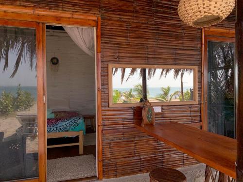 a bedroom with a bed and a window with a view of the ocean at Palo Santo Sanctuary in Canoas De Punta Sal