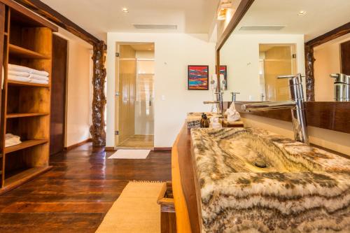 a bathroom with a large sink and a large mirror at Casa Teka in Tulum