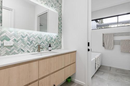 un baño con lavabo y espejo en Honeysuckle House, en Shoreham