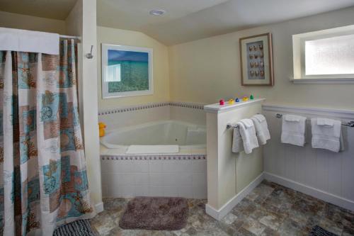 a bathroom with a tub and a shower at Sand Dollar in Seaside