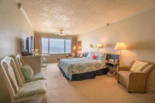a bedroom with a bed and a chair and a window at Sea Gypsy 318 in Lincoln City