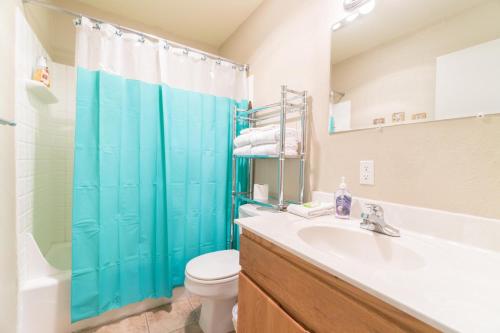 a bathroom with a blue shower curtain and a toilet at Sea Gypsy 318 in Lincoln City