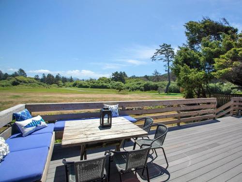 a wooden deck with a wooden table and chairs at Seaside Cove Vue in Seaside