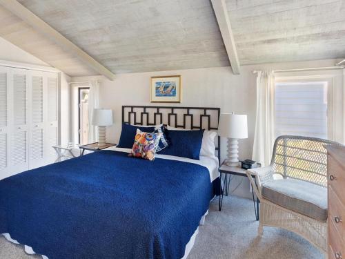 a bedroom with a blue bed and a chair at Seaside Cove Vue in Seaside