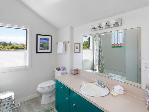 a bathroom with a sink and a toilet and a mirror at Seaside Cove Vue in Seaside
