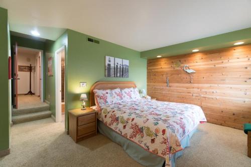a bedroom with a bed and a wooden wall at Admiral 3 in Depoe Bay
