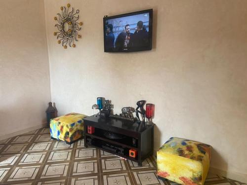 a living room with a flat screen tv on the wall at Résidence Palmariva Aglou in Tiznit