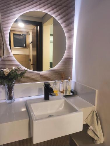 a bathroom with a white sink and a mirror at Hidro, piscina aqc, próx savassi in Belo Horizonte