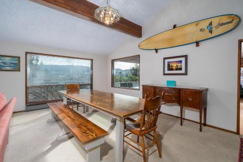 a dining room with a table and a surfboard on the wall at Surfrider Seaside in Seaside