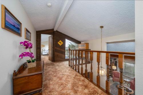 a staircase in a house with purple flowers in a vase at Surfrider Seaside in Seaside