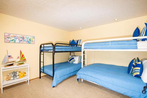two bunk beds in a room with blue beds at Calypso in Lincoln City