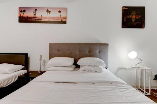 a bedroom with a bed with white sheets and palm trees at Serenity Haven SOCo2BR/2BA DTATX in Austin