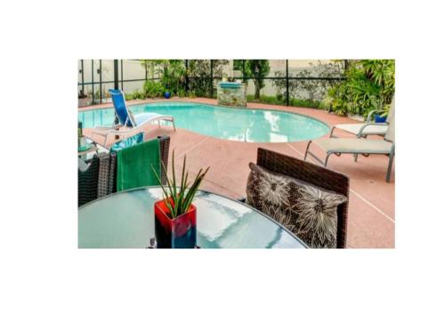 een zwembad met een tafel en twee stoelen en een tafel sidx sidx bij El SHADDAI in Orlando