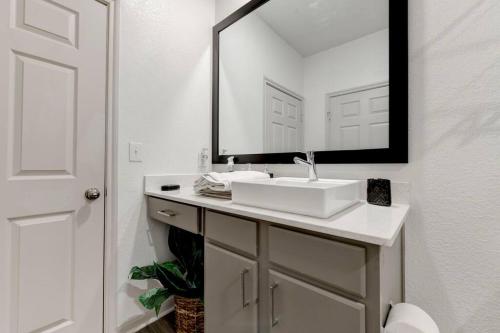 a bathroom with a white sink and a mirror at Serenity Haven SOCo2BR/2BA DTATX in Austin