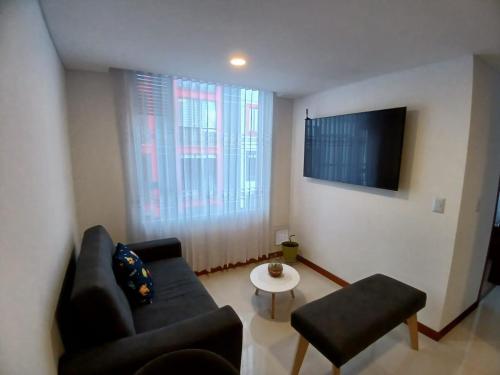 a living room with a couch and a table and a tv at Exclusivo Apartamento Centro Norte in Tunja