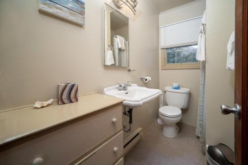 a bathroom with a sink and a toilet and a mirror at Barefoot Bungalow in Seaside