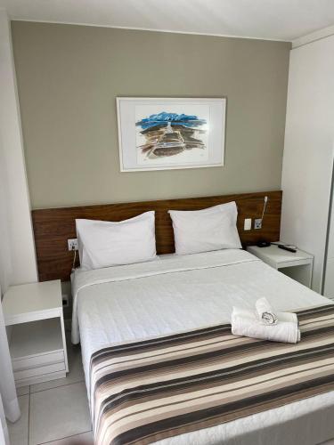 a bedroom with a large bed with a wooden headboard at FLAT FUSION in Brasilia