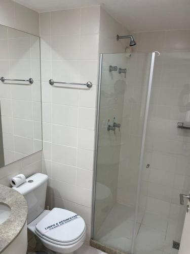 uma casa de banho com um WC e uma cabina de duche em vidro. em FLAT FUSION em Brasília