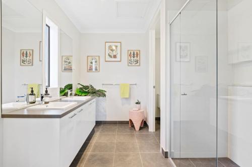 a white bathroom with two sinks and a shower at Cape Retreat in Cape Schanck