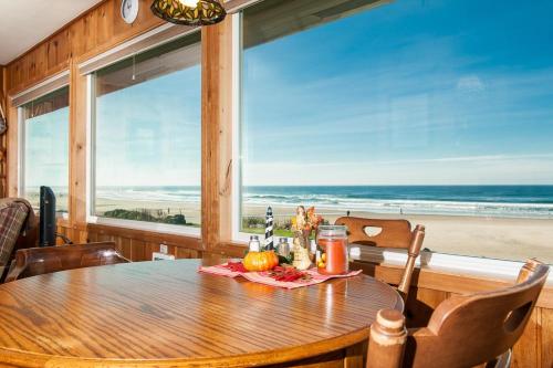 a dining room with a table and a view of the beach at Beach Bungalow - Roads End in Lincoln City