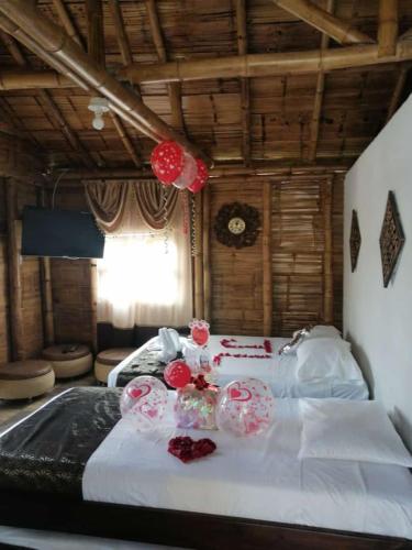 Un dormitorio con dos camas con flores rojas. en Alojamiento Campestre Finca Mi Ranchito, en Pereira