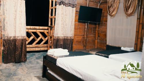 a room with two beds in a log cabin at Alojamiento Campestre Finca Mi Ranchito in Pereira