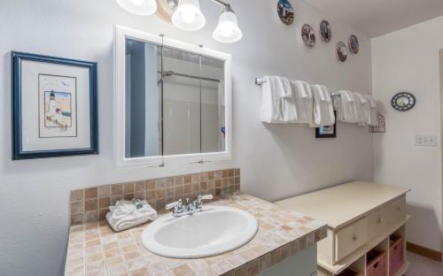 a bathroom with a sink and a mirror at Brass Bell Cottage in Rockaway Beach