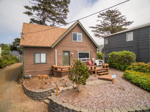 a small house with a yard with a patio at Coral Cottage in Depoe Bay