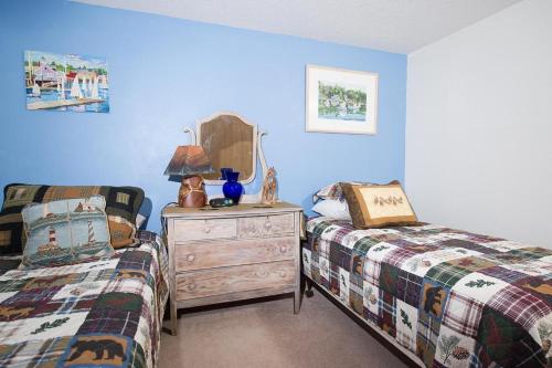 a bedroom with two beds and a dresser with a mirror at Family Tides in Seaside in Seaside