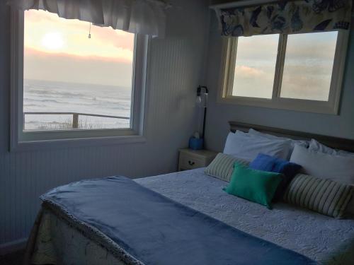 a bedroom with a bed with a view of the ocean at Driftwood Cottage in Seal Rock